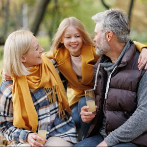 Family enjoying a fall picnic outdoors, smiling and bonding together