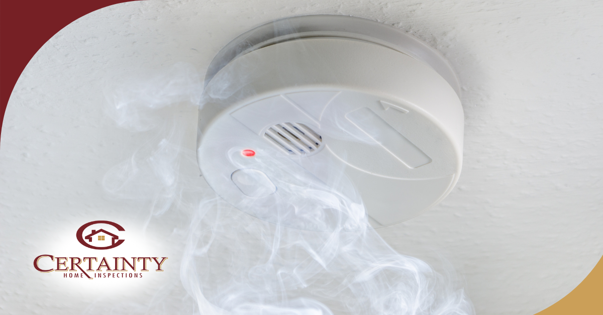 Smoke rising toward a ceiling-mounted smoke detector with an activated red light