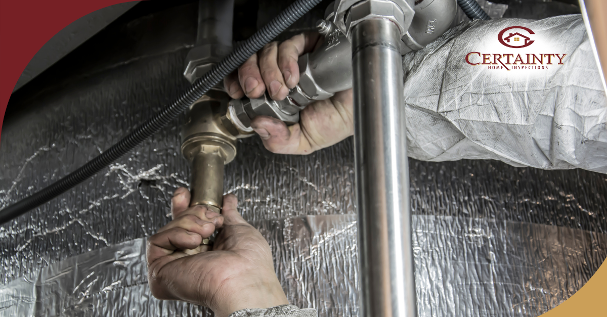 Hands tightening plumbing connections in a utility or inspection setting.